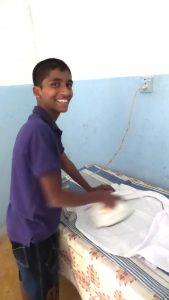 Ironing school uniform. The boys are encouraged to be self sufficient .